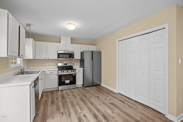 160 Fox Run Rd, Youngsville, NC 27596 - kitchen with appliances with stainless steel finishes, light wood-type flooring, light countertops, and white cabinets