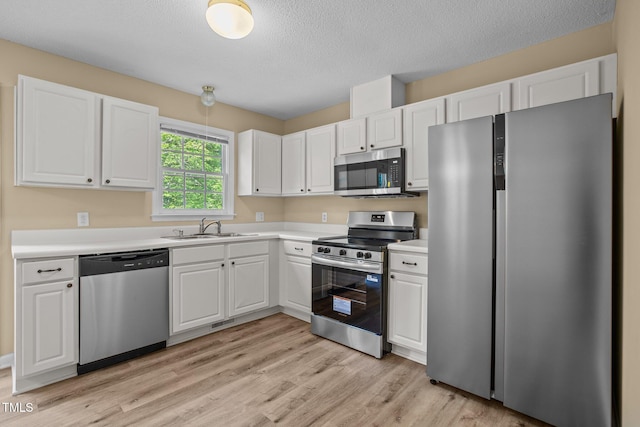 160 Fox Run Rd, Youngsville, NC 27596 - kitchen featuring stainless steel appliances, a sink, white cabinetry, and a textured ceiling