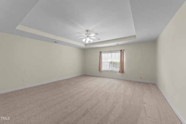 3212 Imperial Oaks Dr, Raleigh, NC 27614 - empty room with light colored carpet, baseboards, a ceiling fan, and a tray ceiling