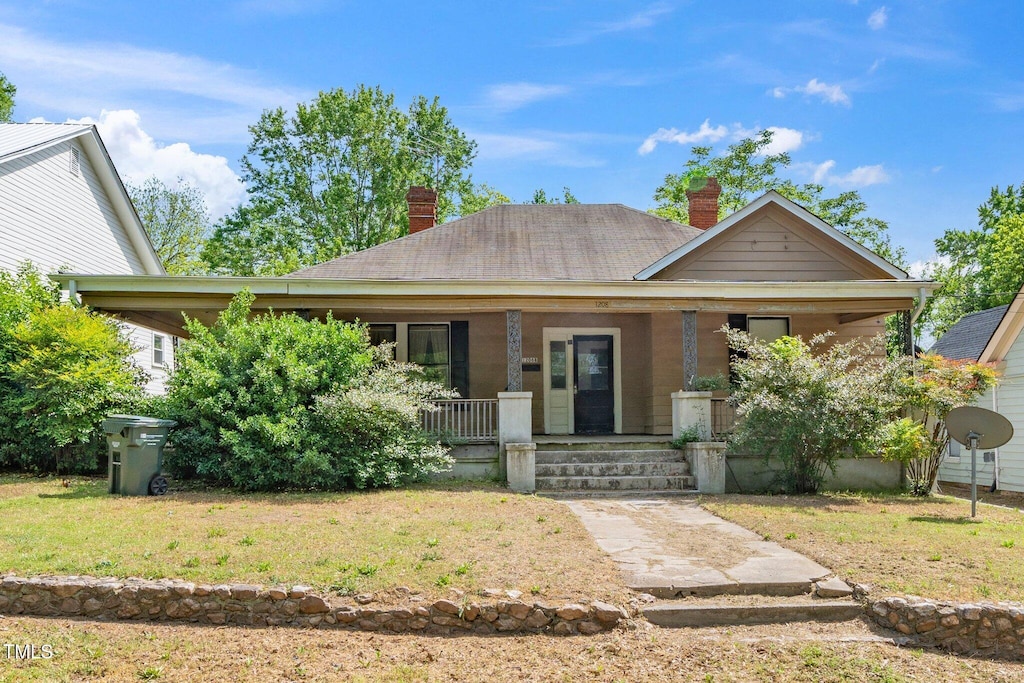 1208 Eva St, Durham, NC 27703 - view of front of property featuring a front lawn, a chimney, and covered porch