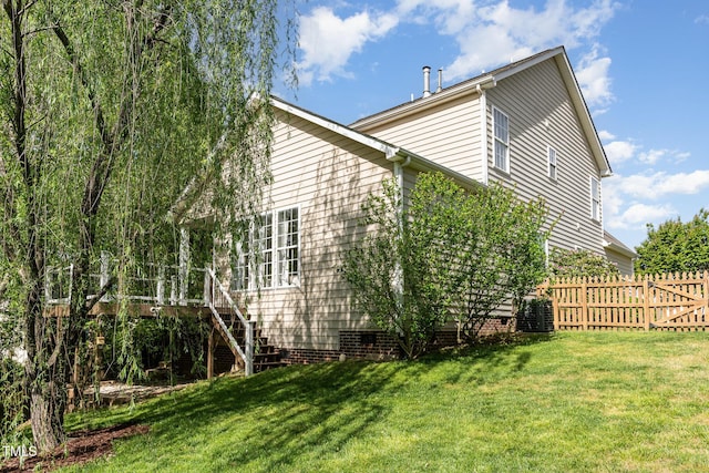 view of side of property with fence, a yard, and stairway