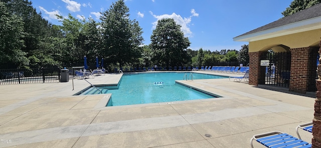pool featuring fence and a patio area