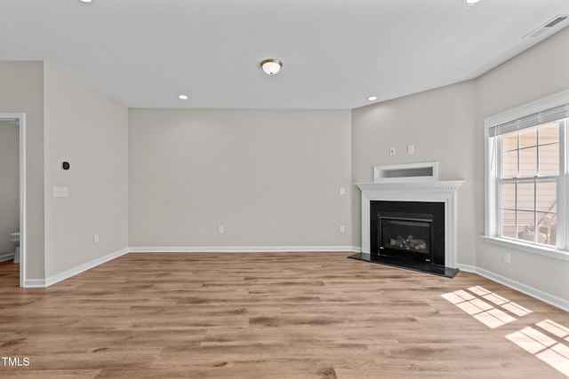 unfurnished living room featuring visible vents, recessed lighting, light wood-style floors, and baseboards