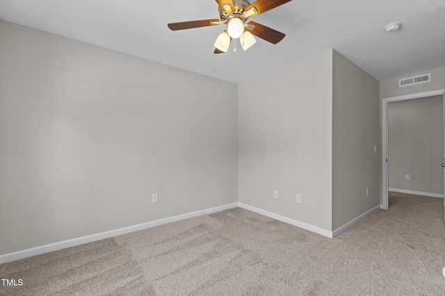 carpeted empty room with a ceiling fan, visible vents, and baseboards