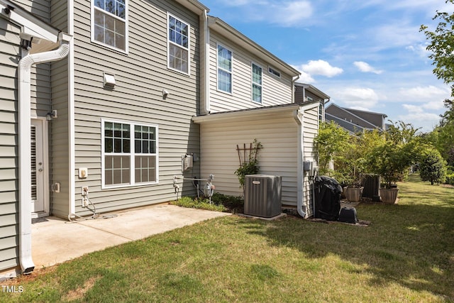 rear view of house with a lawn, central air condition unit, and a patio