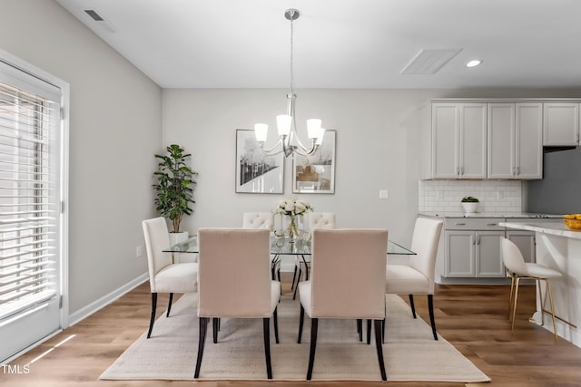 dining space featuring recessed lighting, an inviting chandelier, light wood-style floors, visible vents, and baseboards