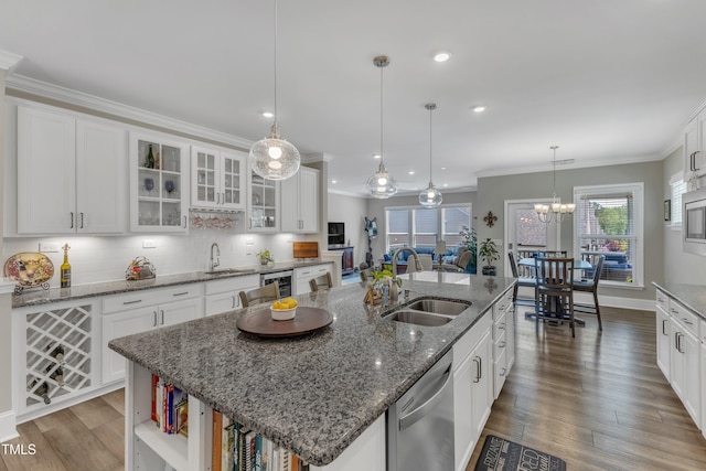 704 Haven Peak Ln, Wake Forest, NC 27587 - kitchen featuring stainless steel appliances, ornamental molding, white cabinets, a kitchen island with sink, and wood finished floors