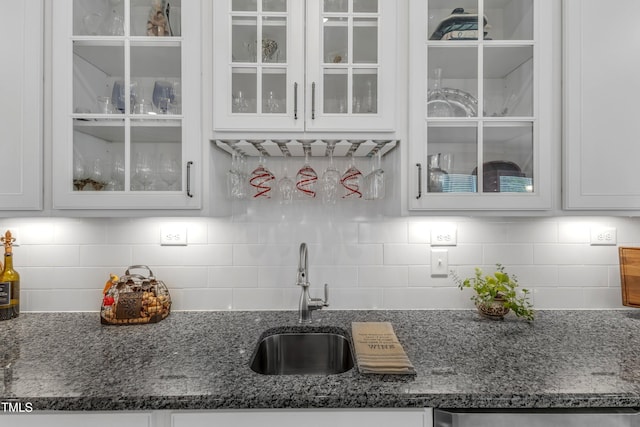704 Haven Peak Ln, Wake Forest, NC 27587 - kitchen featuring white cabinetry, glass insert cabinets, dark stone countertops, and backsplash