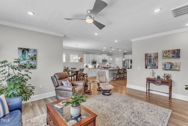 704 Haven Peak Ln, Wake Forest, NC 27587 - living area with crown molding, ceiling fan, light wood finished floors, and recessed lighting