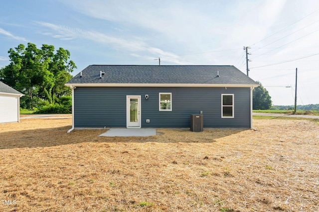 back of property featuring a yard, a patio area, and roof with shingles