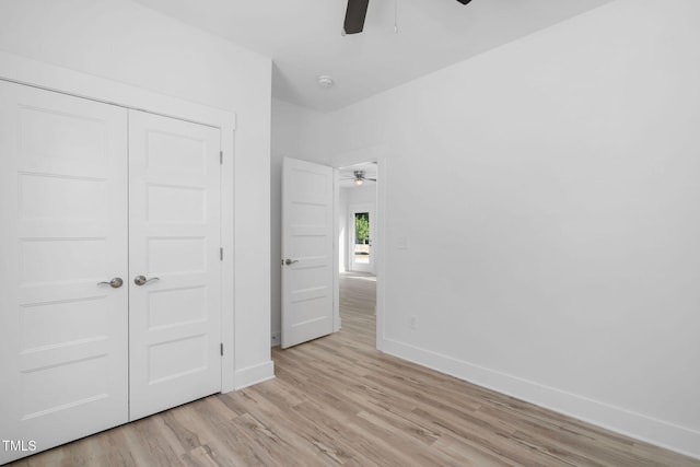 unfurnished bedroom with a ceiling fan, baseboards, a closet, and light wood-type flooring