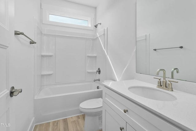 full bath featuring toilet, vanity, wood finished floors, and shower / bath combination