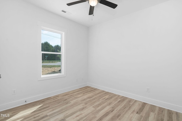 empty room with baseboards, light wood-style flooring, visible vents, and ceiling fan