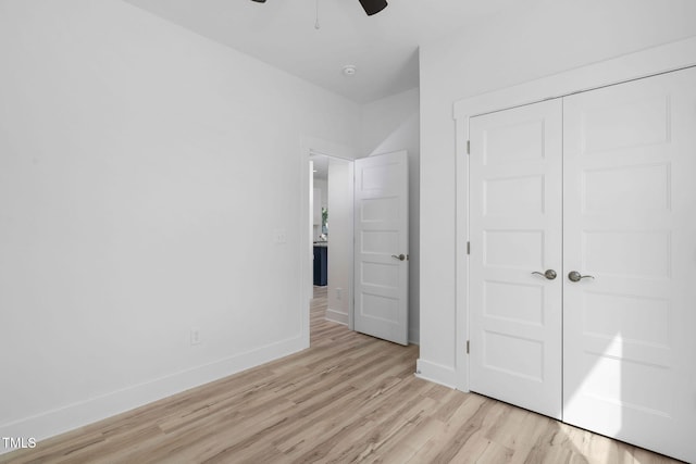 unfurnished bedroom with light wood-type flooring, baseboards, a closet, and ceiling fan