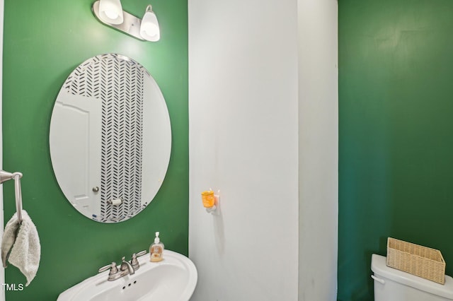 half bath featuring toilet and a sink