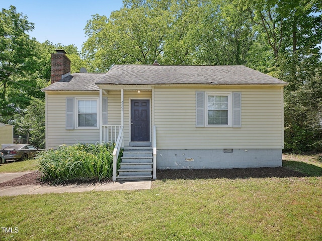 bungalow-style house with crawl space, a chimney, roof with shingles, and a front lawn