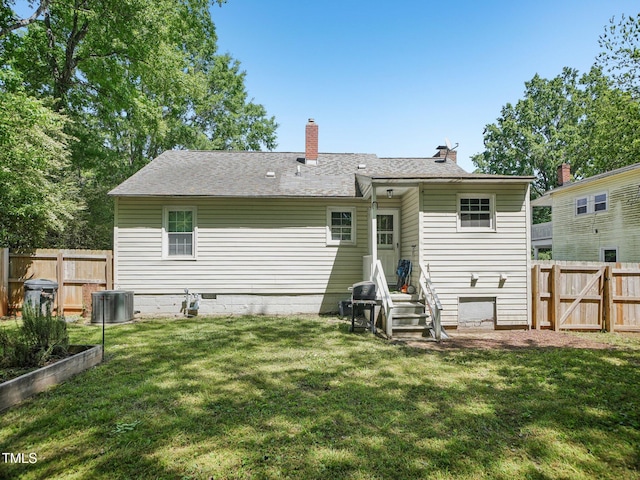 back of property featuring a chimney, a gate, central air condition unit, a fenced backyard, and a yard