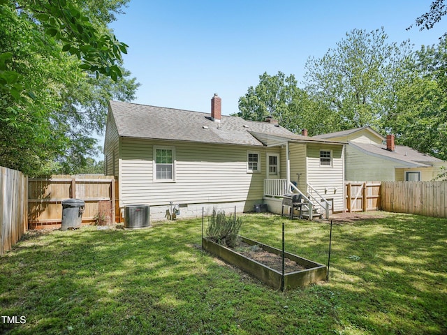 rear view of house featuring a fenced backyard, central AC unit, a yard, and a garden