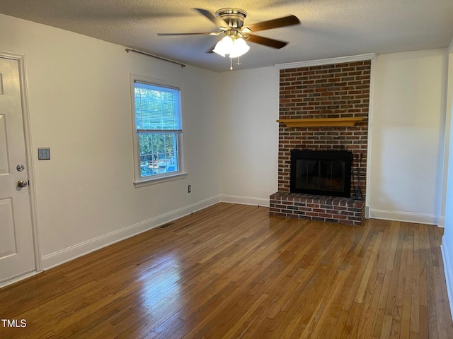 unfurnished living room featuring wood-type flooring, ceiling fan, baseboards, and a fireplace