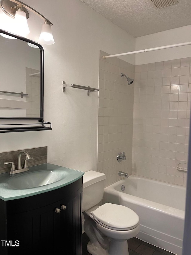 full bathroom featuring shower / tub combination, tile patterned flooring, vanity, toilet, and a textured ceiling