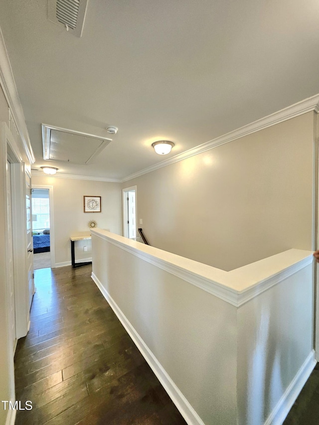hall with attic access, dark wood-style floors, baseboards, an upstairs landing, and ornamental molding