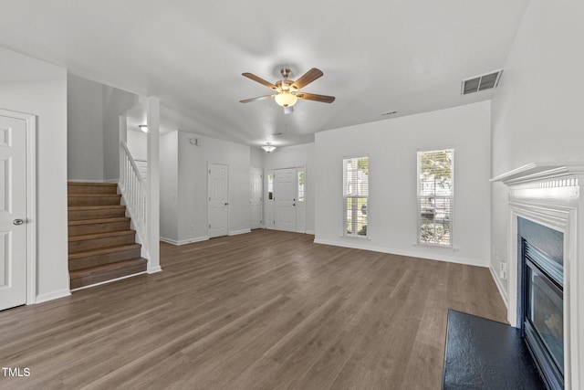 620 Hanska Way, Raleigh, NC 27610 - unfurnished living room featuring a glass covered fireplace, ceiling fan, stairway, wood finished floors, and baseboards