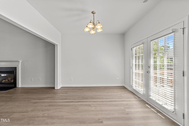 620 Hanska Way, Raleigh, NC 27610 - unfurnished living room with a chandelier, a glass covered fireplace, light wood-style flooring, and baseboards