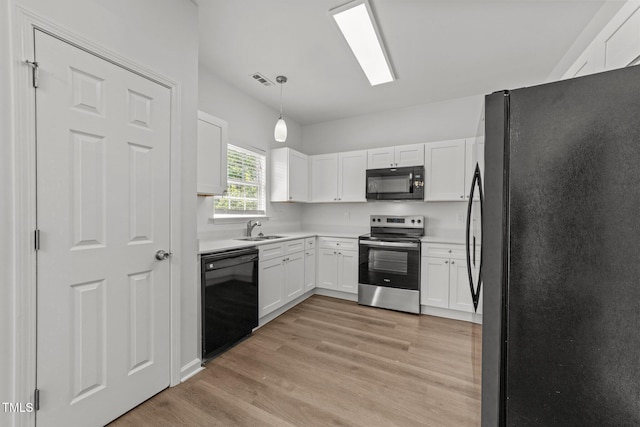 620 Hanska Way, Raleigh, NC 27610 - kitchen featuring black appliances, a sink, light wood-style floors, white cabinetry, and pendant lighting