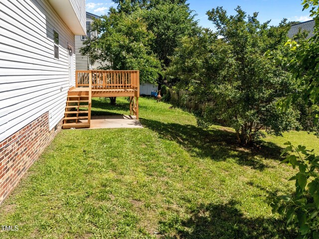 620 Hanska Way, Raleigh, NC 27610 - view of green lawn featuring a wooden deck and a patio area