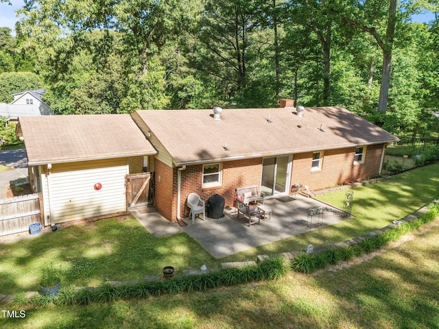 back of house featuring a lawn, a patio area, brick siding, fence, and a shingled roof