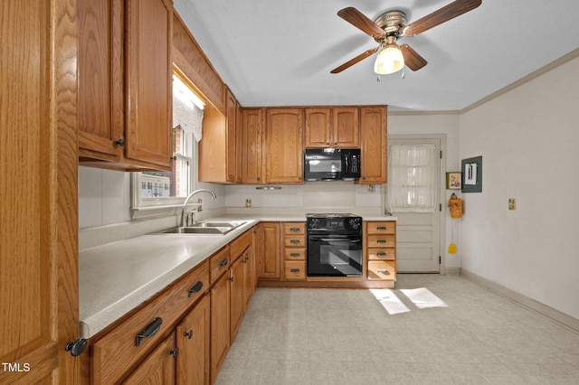 kitchen with black microwave, a sink, light countertops, range, and brown cabinetry