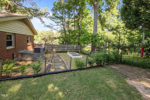 view of yard with a fenced backyard, central AC, and a vegetable garden