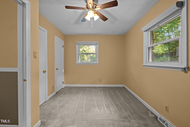 unfurnished bedroom with baseboards, carpet flooring, a textured ceiling, and visible vents