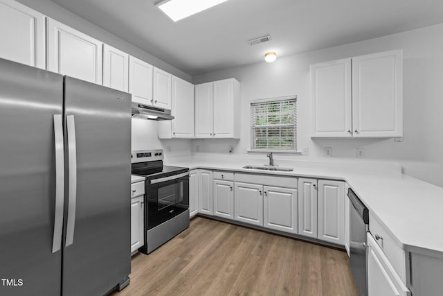 633 Prickly Pear Dr, Fuquay Varina, NC 27526 - kitchen featuring appliances with stainless steel finishes, a sink, under cabinet range hood, light wood-style floors, and white cabinets