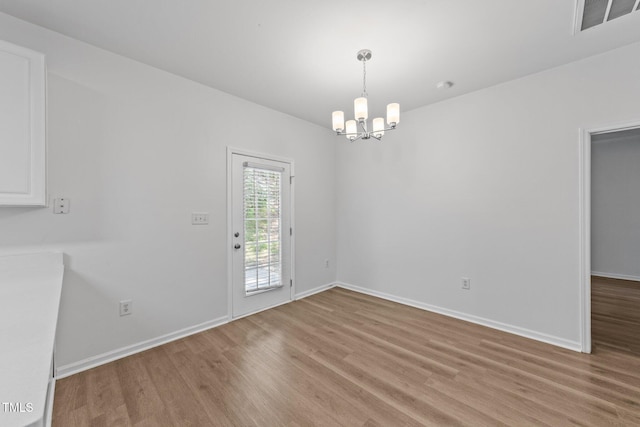633 Prickly Pear Dr, Fuquay Varina, NC 27526 - unfurnished dining area with light wood-style flooring, a chandelier, and baseboards