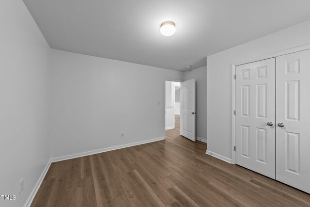 633 Prickly Pear Dr, Fuquay Varina, NC 27526 - unfurnished bedroom featuring dark wood finished floors, baseboards, and a closet