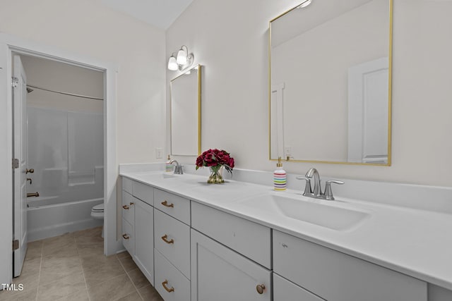 bathroom featuring double vanity, a sink, tile patterned flooring, and toilet
