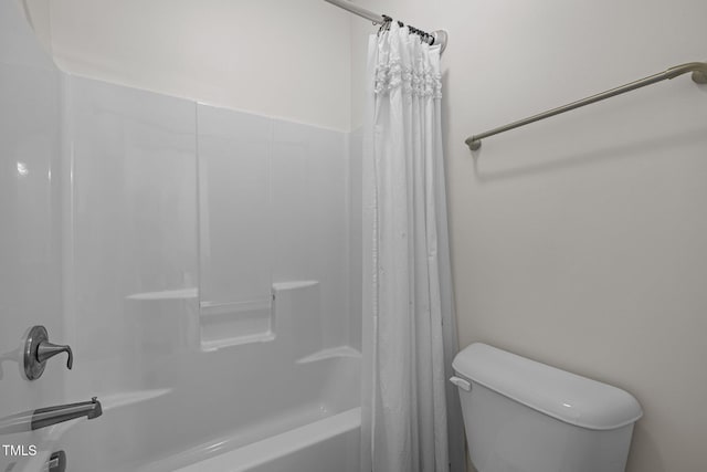 full bathroom featuring shower / bath combo with shower curtain and toilet
