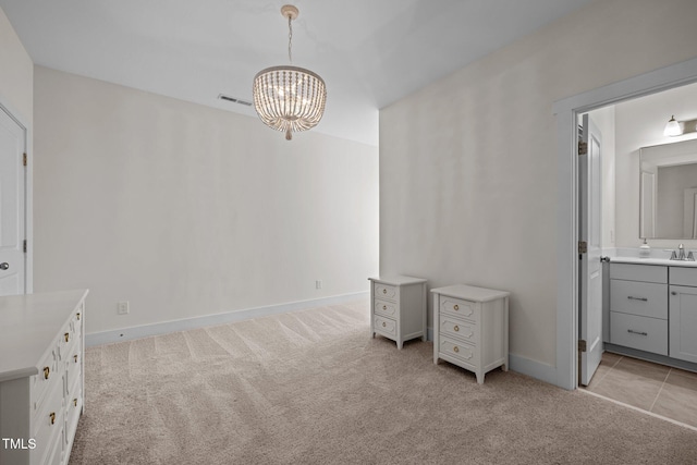unfurnished bedroom featuring visible vents, light colored carpet, a sink, an inviting chandelier, and ensuite bathroom