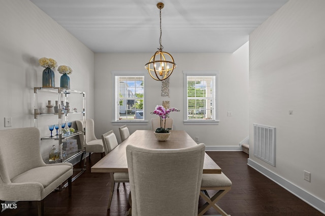 dining room with visible vents, dark wood-style flooring, baseboards, and a notable chandelier