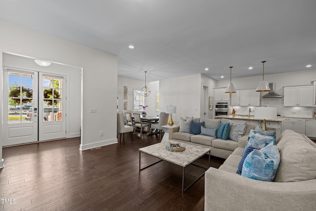 living area with recessed lighting, dark wood finished floors, and a healthy amount of sunlight