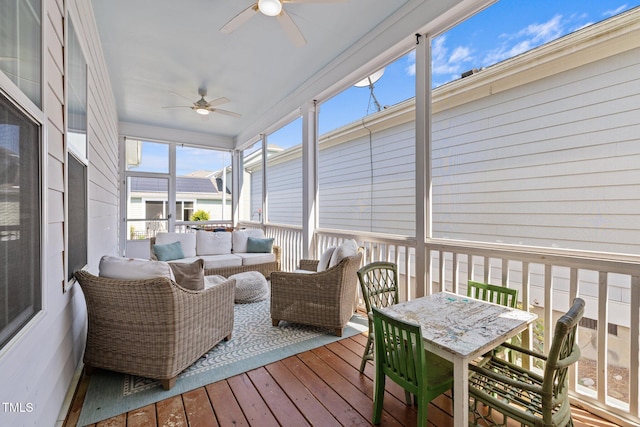 sunroom with ceiling fan and an outdoor living space