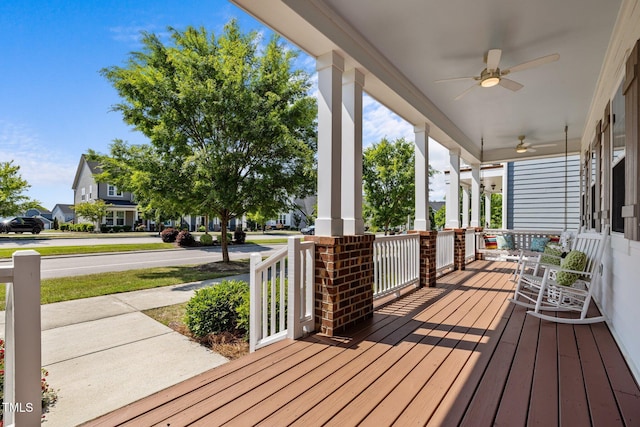 wooden deck featuring a porch, ceiling fan, and a residential view