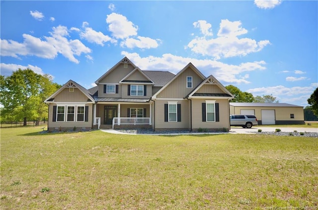 6226 Deerstand Rd, Wade, NC 28395 - view of front of house with covered porch, a front yard, board and batten siding, metal roof, and a detached garage