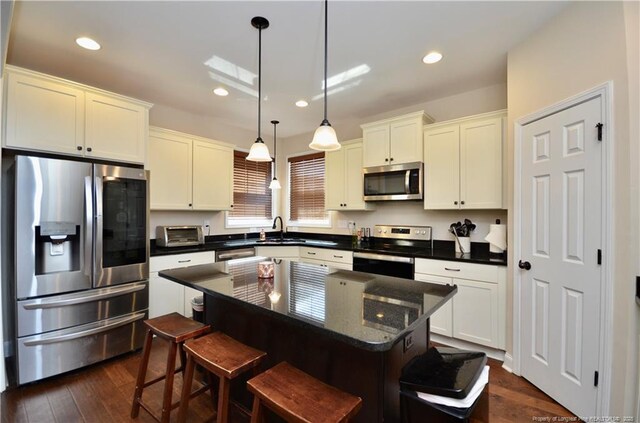 6226 Deerstand Rd, Wade, NC 28395 - kitchen featuring appliances with stainless steel finishes, a sink, hanging light fixtures, a center island, and dark wood-style floors