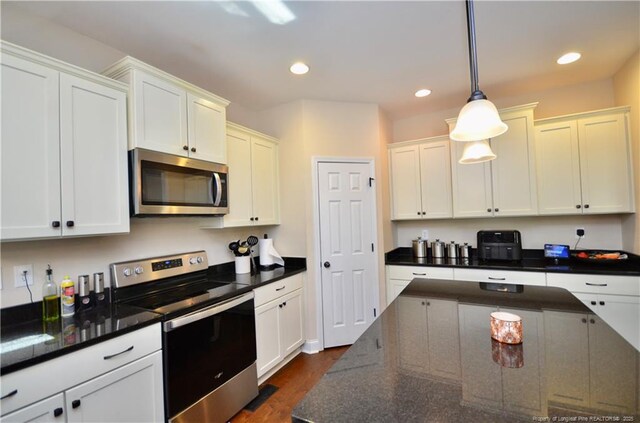 6226 Deerstand Rd, Wade, NC 28395 - kitchen with appliances with stainless steel finishes, dark wood-style floors, decorative light fixtures, white cabinetry, and recessed lighting