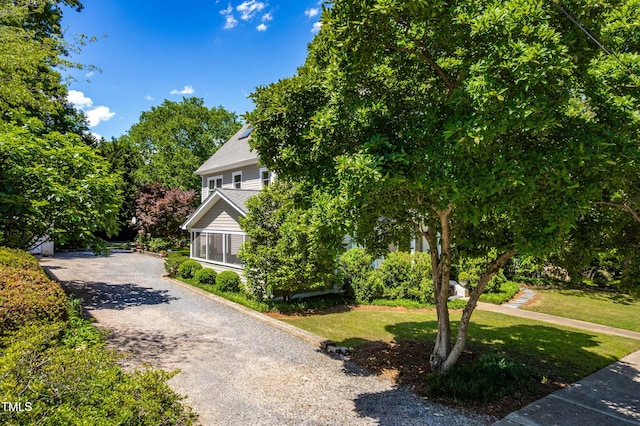 obstructed view of property featuring a front lawn and driveway