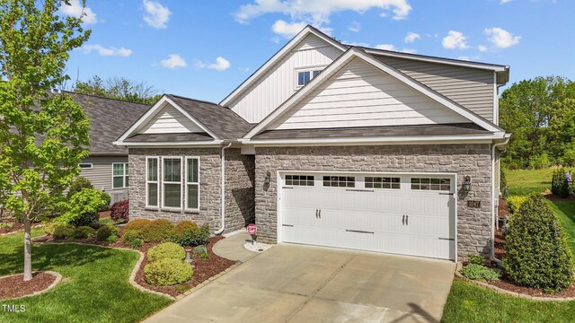 1047 Aberlour Ln, Burlington, NC 27215 - craftsman-style house with a front lawn, driveway, stone siding, board and batten siding, and a garage