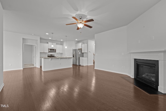 1047 Aberlour Ln, Burlington, NC 27215 - unfurnished living room featuring a ceiling fan, a glass covered fireplace, dark wood finished floors, baseboards, and recessed lighting