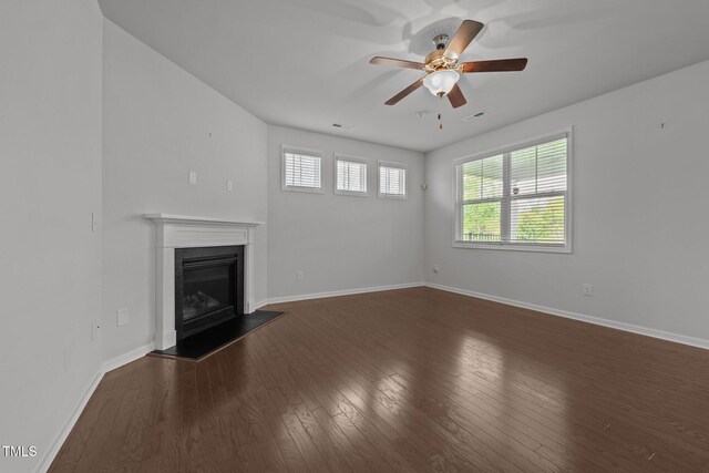 1047 Aberlour Ln, Burlington, NC 27215 - unfurnished living room with a glass covered fireplace, ceiling fan, baseboards, dark wood-type flooring, and visible vents